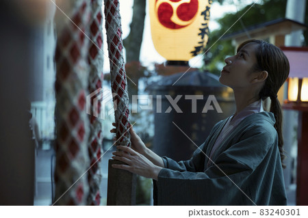 In the evening, a tourist woman who visits Ikaho Shrine rings a bell (hontsubo) 83240301