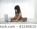 Portrait of asian girl typing on laptop computer studying in bed room, asian toddler girl look at notebook laptop screen. Education knowledge technology internet lifestyle, back to school concept 83240610