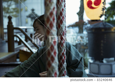 In the evening, a tourist woman worshiping at Ikaho Shrine puts in a gift 83240646