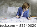 Portrait of young designer business woman designing layout. Business prototype house sketch plan. Design studio architect creative occupation blueprint idea concept. 83240820