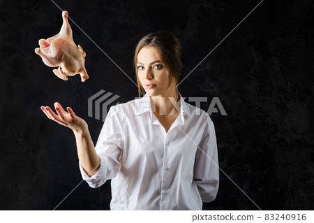 Young woman tossing chicken up 83240916