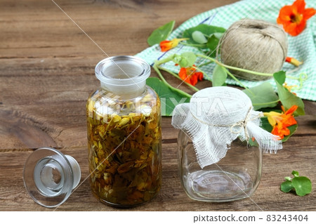 Making tincture from Tropaeolum majus, also called garden nasturtium or Indian cress. 83243404