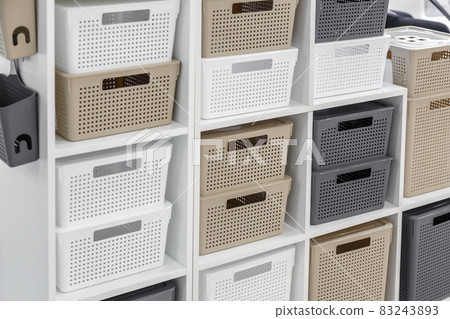 Plastic container boxes on a shelf on a rack for organizing home space and storing things, order and interior, selling household goods. Industrial background 83243893
