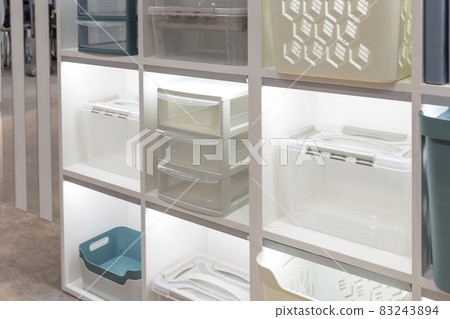 Plastic container boxes on a shelf on a rack for organizing home space and storing things, order and interior, selling household goods. Industrial background 83243894