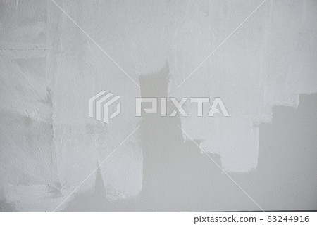 Painted wall background, Painter painting a house wall with a paint poller Painted wall background, Painter painting a house wall with a paint poller 83244916