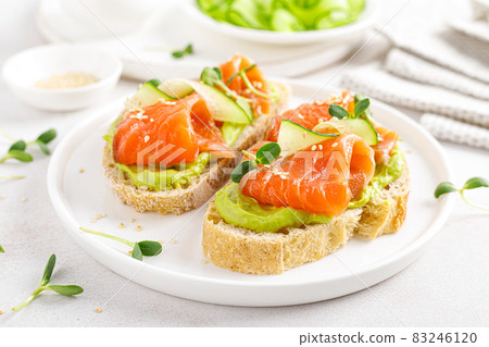 Open sandwiches with salted salmon, guacamole avocado and microgreens. Seafood. Healthy food. 83246120