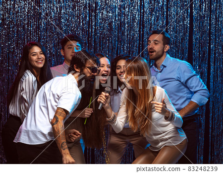 Enjoying karaoke. Group of young people having fun at the celebration 83248239