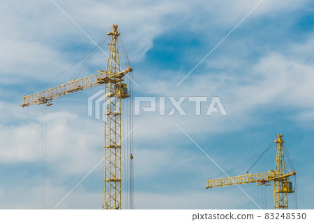 Tower industrial construction yellow crane against the blue sky 83248530