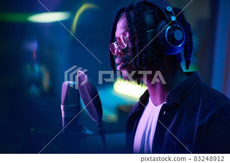 African man recording a song in the studio 83248912