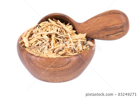 Muira Puama herbal tea in wooden bowl and spoon, isolated on white background. Natural potency wood, medicinal plant, dry tea. Ptychopetalum olacoides. 83249271
