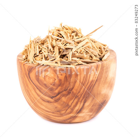Muira Puama herbal tea in olive bowl, isolated on white background. Natural potency wood, medicinal plant, dry tea. Ptychopetalum olacoides. 83249273