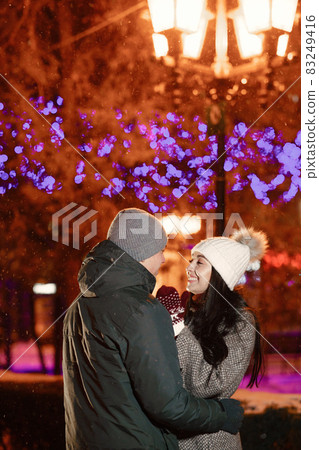 Young couple outdoor in night street at christmas time Young couple outdoor in night street at christmas time 83249416