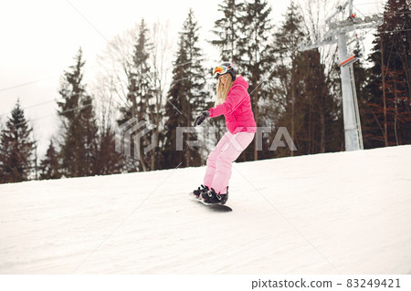 Girl snowboarding in the mountains with the snowboard Girl snowboarding in the mountains with the snowboard 83249421