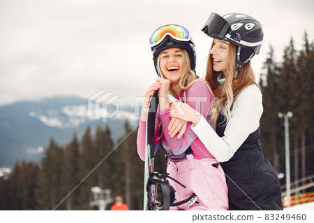 Girls snowboarding in the mountains with the snowboard Girls snowboarding in the mountains with the snowboard 83249460