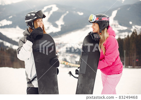Girls snowboarding in the mountains with the snowboard Girls snowboarding in the mountains with the snowboard 83249468