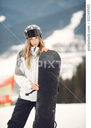 Girl snowboarding in the mountains with the snowboard 83249505
