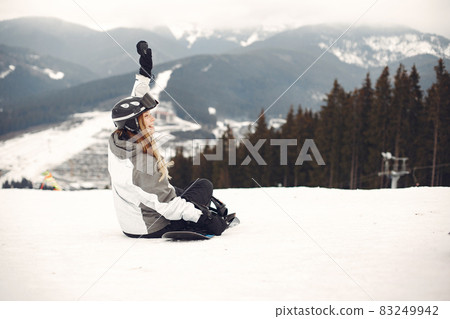 Girl snowboarding in the mountains with the snowboard Girl snowboarding in the mountains with the snowboard 83249942