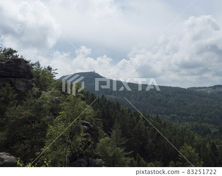 View from sandstone rock viewpoint Monchskanzeland on spruce tree forest, village Oybin and Zittauer Gebirge mountains nature park, summer landscape, Germany 83251722