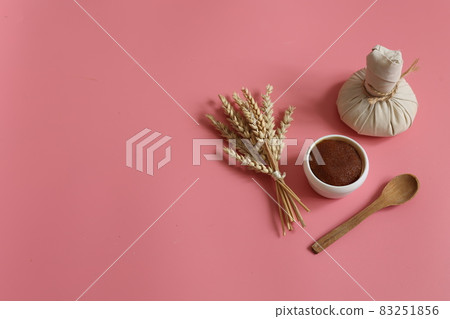 Spa composition with scrub, herbal bag and wooden spoon on a pink background. 83251856