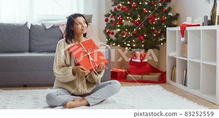Woman With Present in the Gift Box Near Christmas Tree at Home 83252559