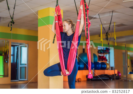 Young beautiful woman practicing aerial yoga in gym. Lifestyle 83252817
