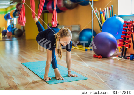 Young beautiful woman practicing aerial yoga in gym. Lifestyle 83252818
