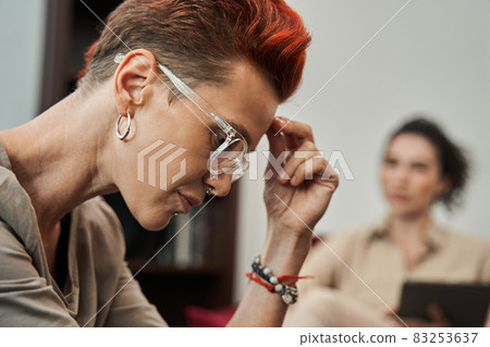 Woman in casual clothes is looking down and telling about her problems 83253637