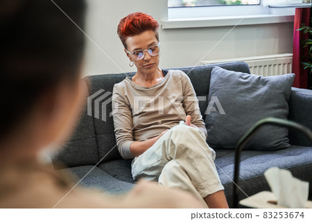 Woman pondering about her problems while her psychotherapist writing notes Woman pondering about her problems while her psychotherapist writing notes 83253674