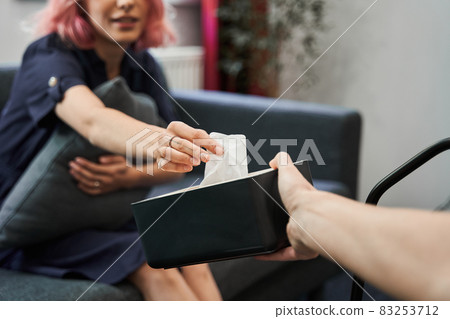 Psychologist giving napkins to her crying female patient during the session Psychologist giving napkins to her crying female patient during the session 83253712