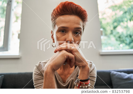 Sad woman sitting on couch at home and talking to female psychologist on computer screen Sad woman sitting on couch at home and talking to female psychologist on computer screen 83253798