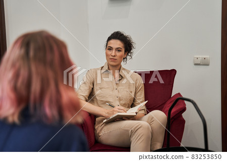 Female friendly psychologist talking with patients on therapy session Female friendly psychologist talking with patients on therapy session 83253850