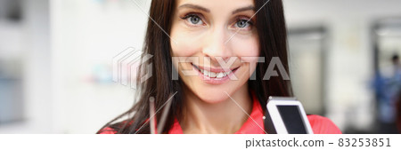 Young woman hairdresser holding scissors and hair clipper in hands 83253851