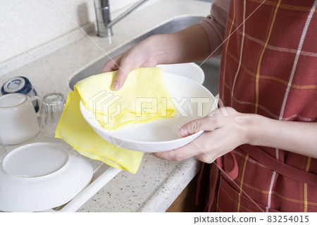 一個女人的手在廚房裡擦盤子 一個女人的手在廚房裡擦盤子 83254015