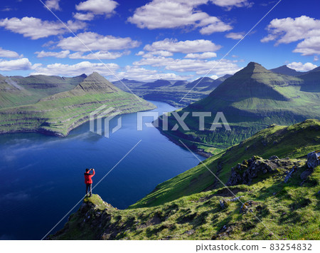 Tourist photographs view of Funningur fjord and nearby mountains, Faroe Islands 83254832