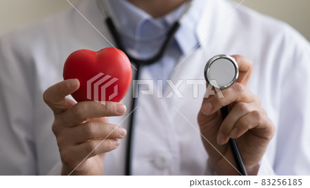 Young female cardiologist holding red heart and stethoscope 83256185