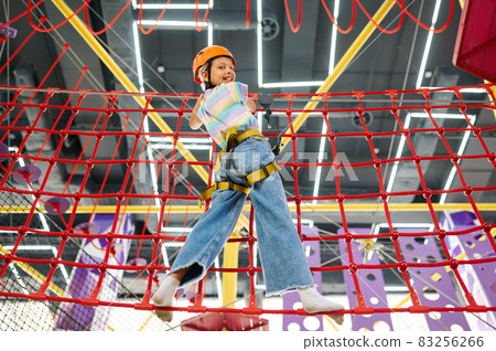 Little girl holding on to the ropes, zip line Little girl holding on to the ropes, zip line 83256266