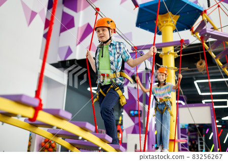 Happy children on zip line in entertainment center Happy children on zip line in entertainment center 83256267