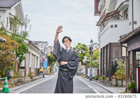 A young man looking at the camera wearing a kimono and taking a walk A young man looking at the camera wearing a kimono and taking a walk 83260675