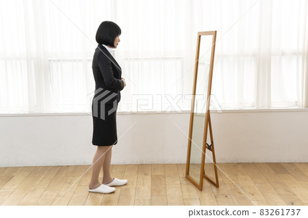 A woman wearing a suit in front of a full-length look 83261737