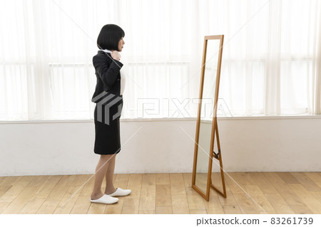 A woman wearing a jacket in front of a full-length look 83261739