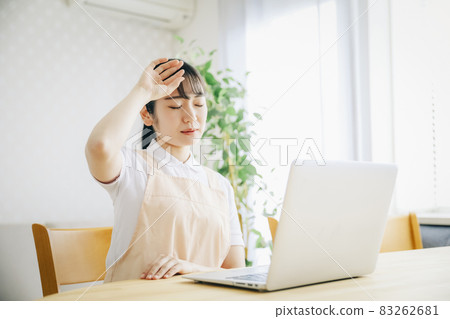 一個穿著圍裙的女人使用電腦(疲勞) 一個穿著圍裙的女人使用電腦(疲勞) 83262681