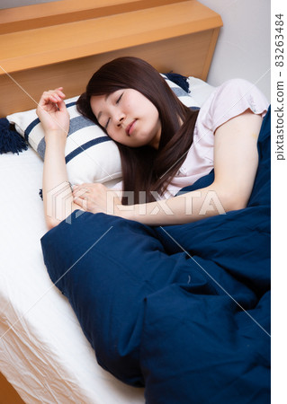 Young Japanese woman sleeping in bed Young Japanese woman sleeping in bed 83263484