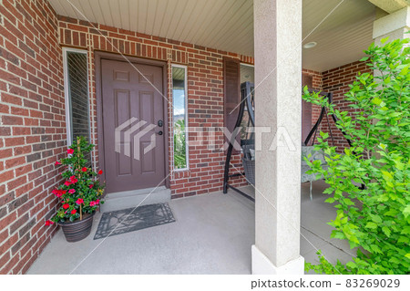Home with red brick exterior wall and brown front door between narrow sidelights Home with red brick exterior wall and brown front door between narrow sidelights 83269029