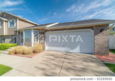 Beautiful house facade with attached garage stone brick wall and bay window 83269080