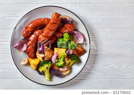 Sausage and vegetables on white wooden background 83270602