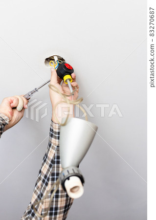 man disassembles defected ceiling lamp man disassembles defected ceiling lamp 83270687