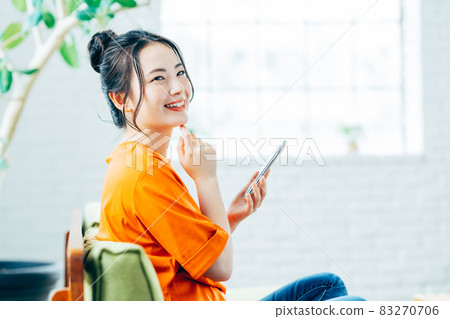 年輕女子在客廳看智慧型手機 年輕女子在客廳看智慧型手機 83270706