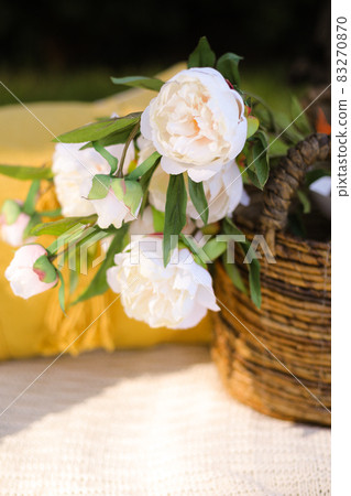 Romance, love, valentine's day concept - wicker basket with bouquet of flower on the grass. Spring fresh sunny background. Selective focus 83270870