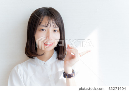 一個微笑的女人用左手指著她的手指 一個微笑的女人用左手指著她的手指 83271604