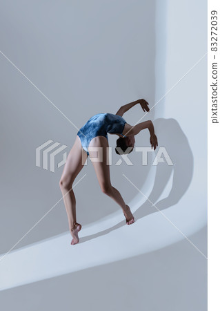 Young and graceful ballet dancer, ballerina dancing isolated on light studio background. Art, motion, action, flexibility, inspiration concept. Young and graceful ballet dancer, ballerina dancing isolated on light studio background. Art, motion, action, flexibility, inspiration concept. 83272039